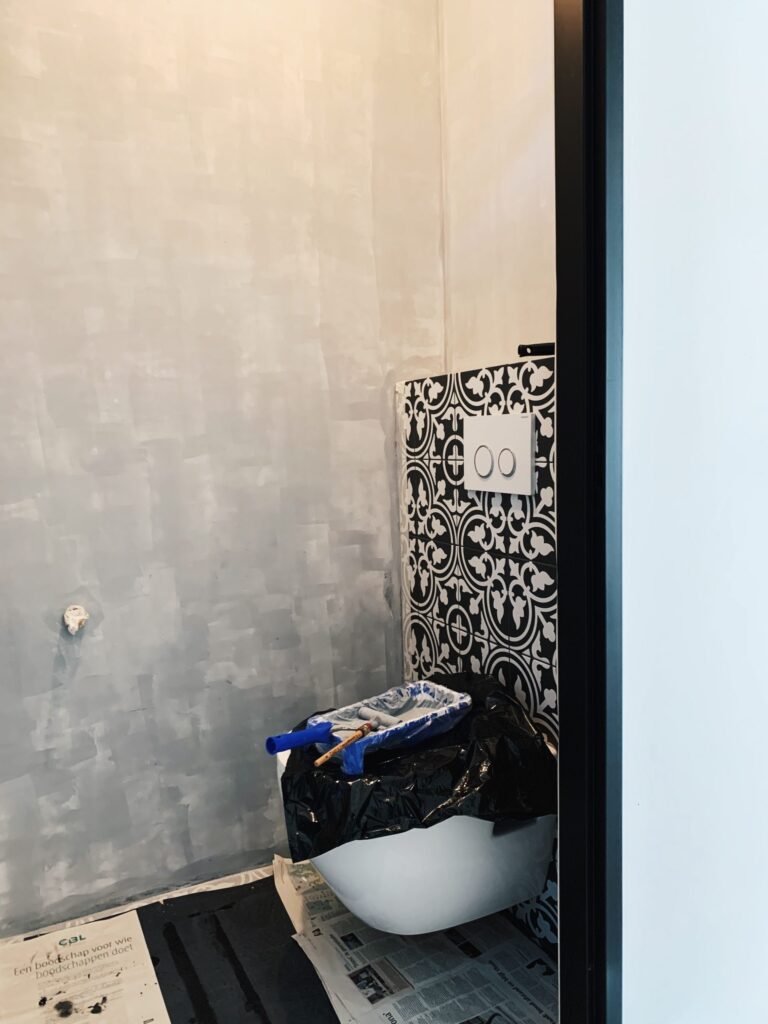 eerste laag betonlook muurverf op de muur in het toilet