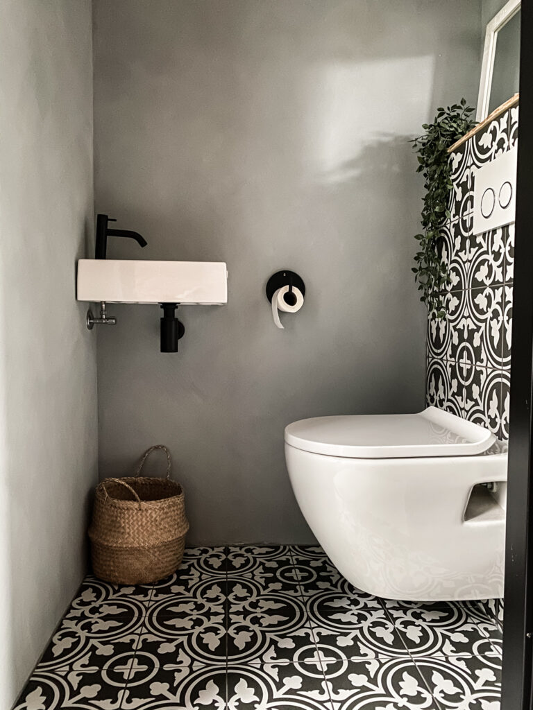 toilet met portugese tegels en betonlook muren