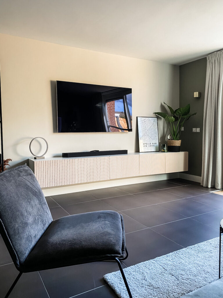 Resultaat interieuradvies woonkamer Capelle aan den IJssel. tv-hoek met besta tv meubel van Ikea met latjes. Groene zijwand in Camouflage Green van Flexa en beige achterwand in de kleur Mushroom van Vestingh