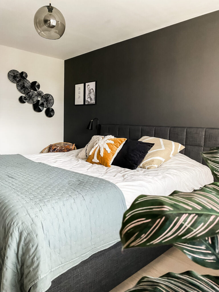 Resultaat interieuradvies slaapkamer Capelle aan den IJssel. Met zwarte muur en groene bedsprei, kussentjes ter decoratie