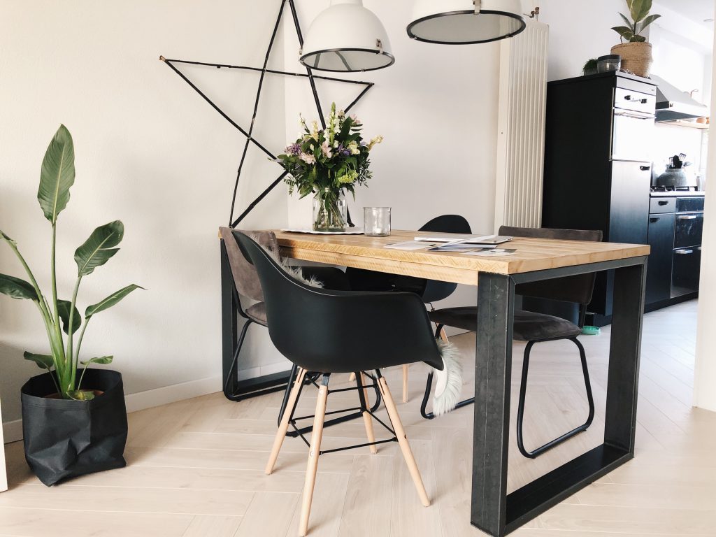 de eethoek met industriële eettafel waar de muurkleur 'zee' in het midden van de tafel stopt.